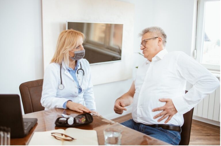 A male patient in his mid-thirties is being examined by a female doctor in her office. The patient is expressing his discomfort with pancreatic pain. The female doctor explains the causes of pancreas atrophy